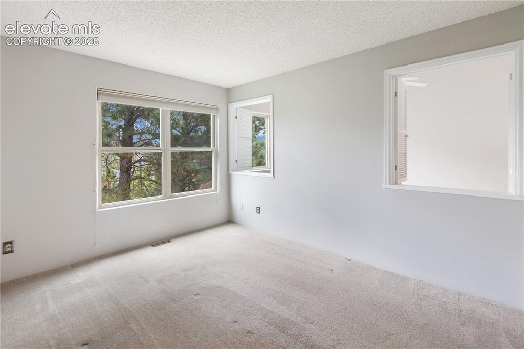 Image 26 of 34: Upper bedroom with peekaboo windows to living room