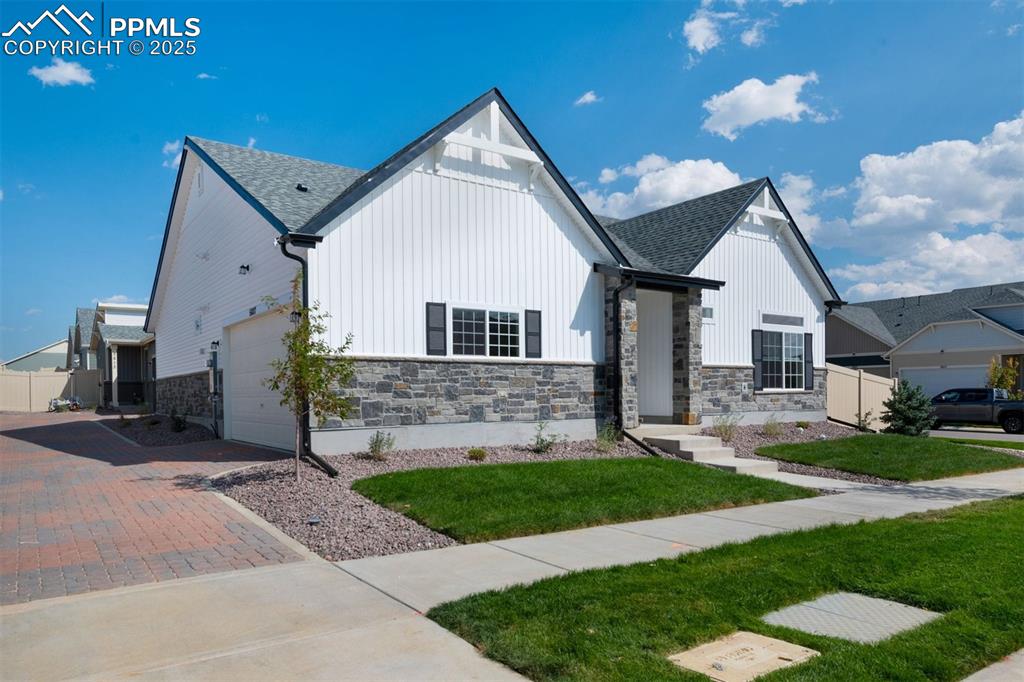Image 2 of 33: View of front of house featuring stone siding, board and batten siding, an