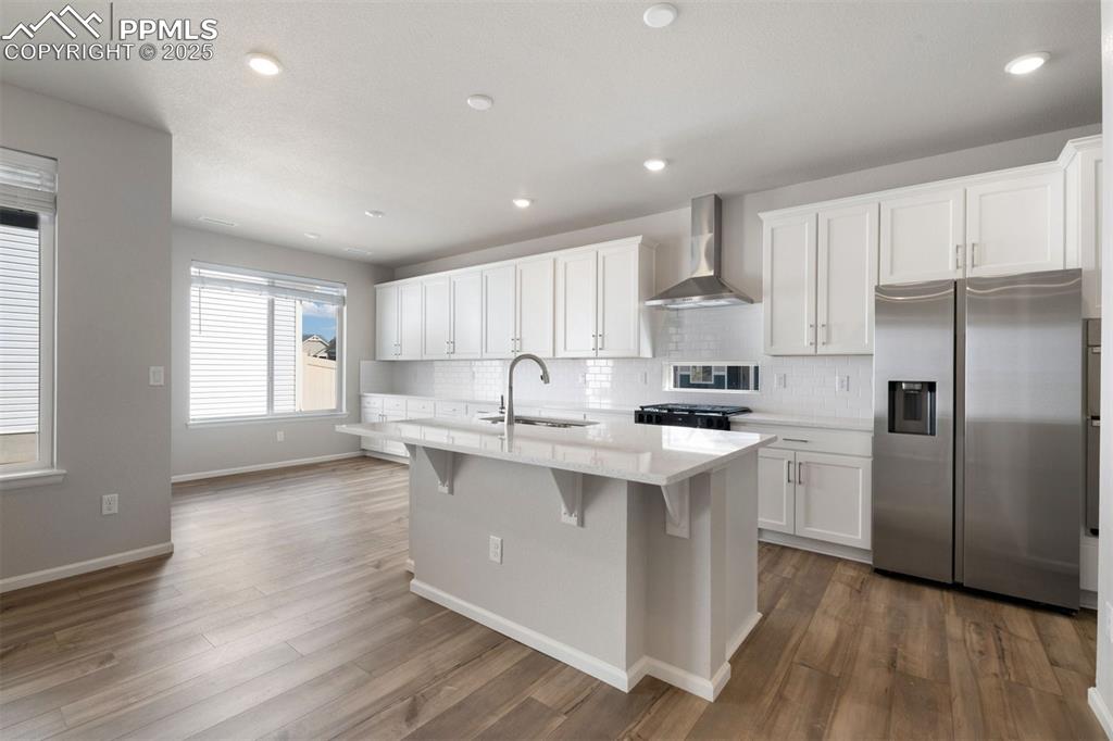 Image 20 of 33: Kitchen featuring stainless steel refrigerator with ice dispenser, white ca