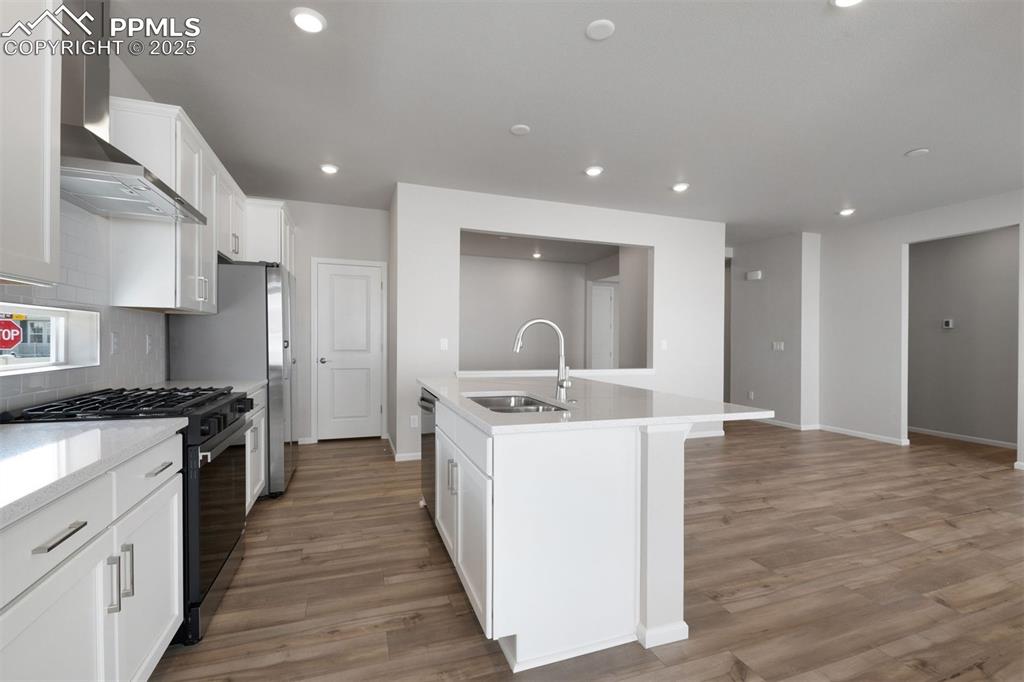 Image 22 of 33: Kitchen featuring stainless steel appliances, wall chimney exhaust hood, wh