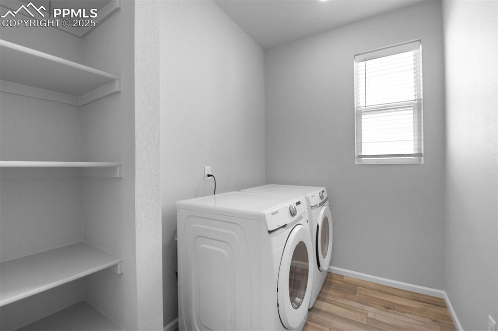 Image 24 of 33: Laundry area featuring wood finished floors and independent washer and drye