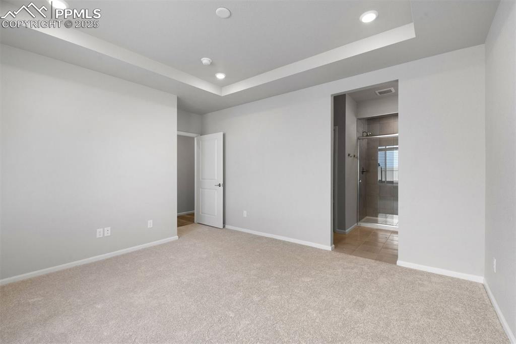 Image 29 of 33: Unfurnished bedroom with a raised ceiling, light colored carpet, recessed l