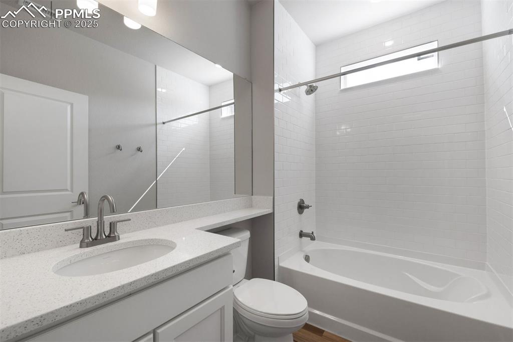 Image 30 of 33: Bathroom featuring bathtub / shower combination, vanity, and dark wood fini