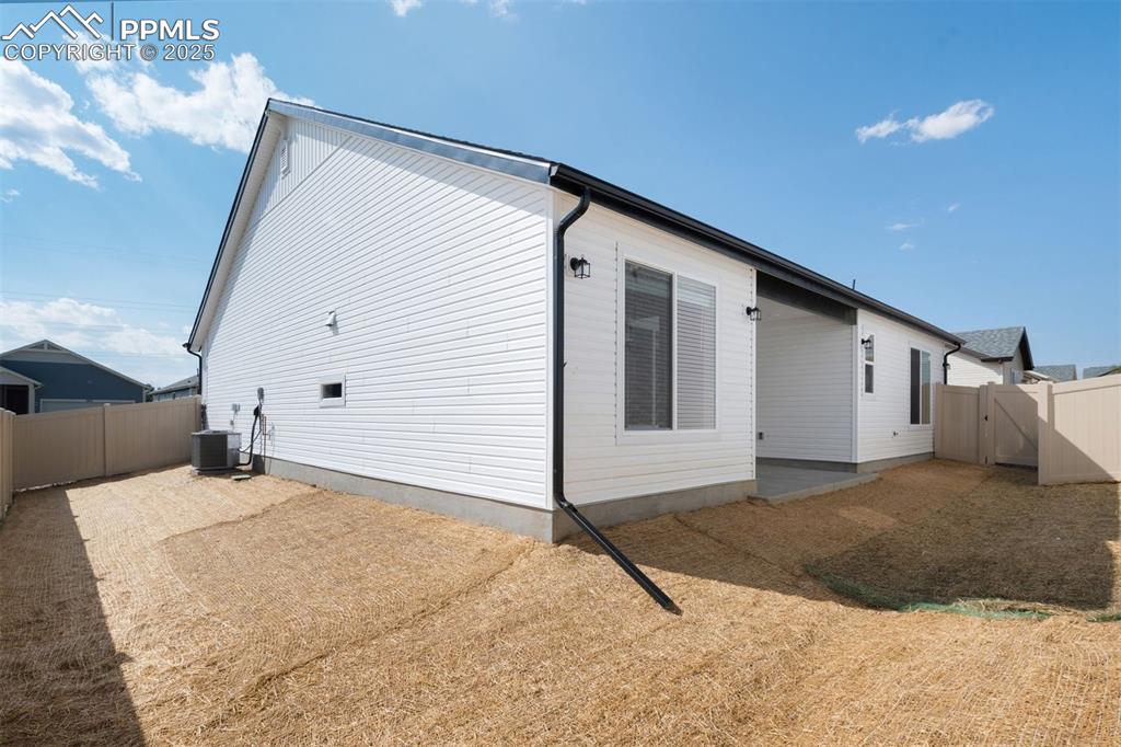 Image 7 of 33: View of side of property featuring a fenced backyard and a gate