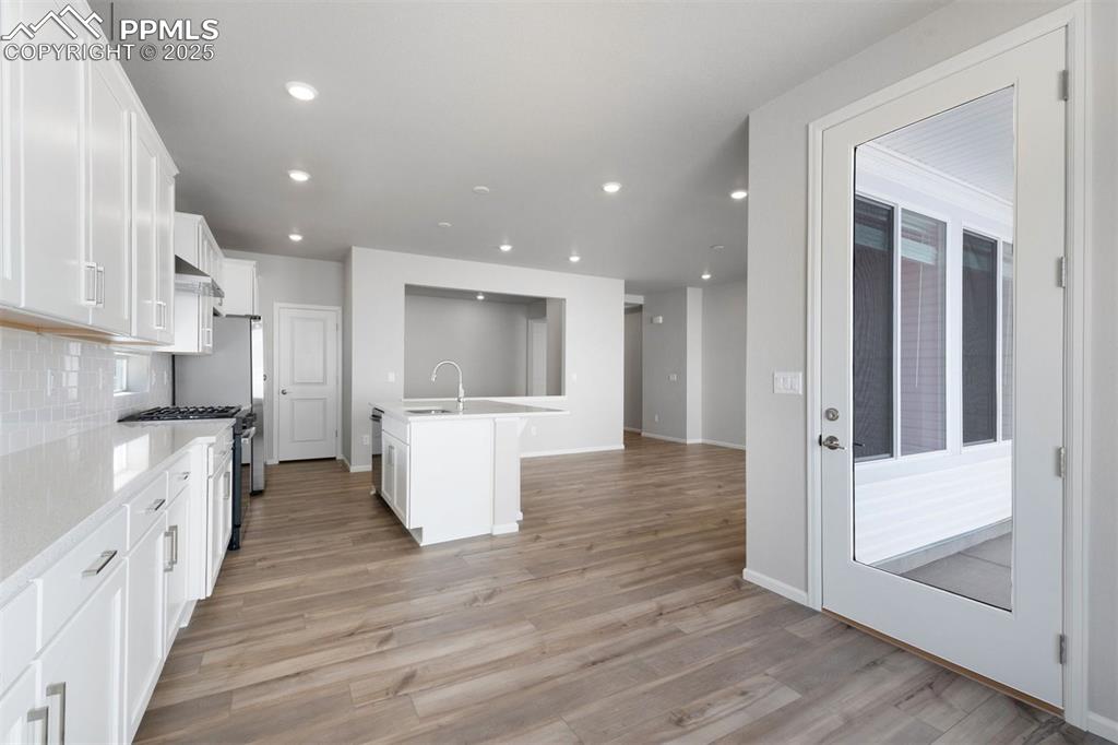 Image 9 of 33: Kitchen featuring white cabinets, stainless steel appliances, tasteful back