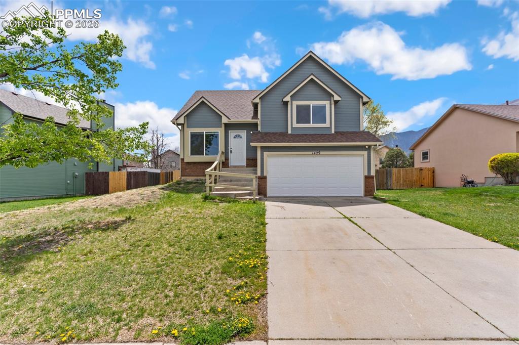 Caption: View of front facade featuring brick siding, an attached garage, and concrete driveway