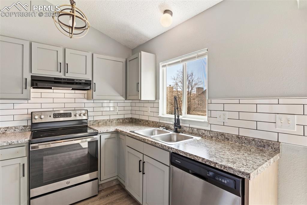 Image 10 of 35: Kitchen featuring stainless steel appliances, light countertops, tasteful b