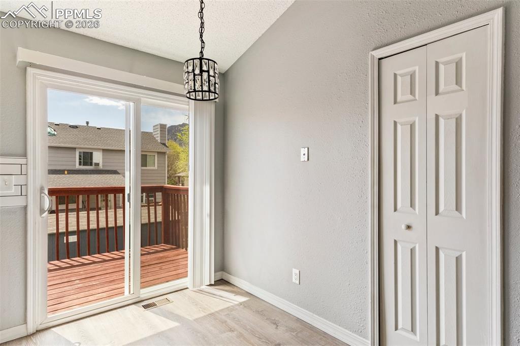 Image 14 of 35: Doorway to outside featuring a textured wall, wood finished floors, and han