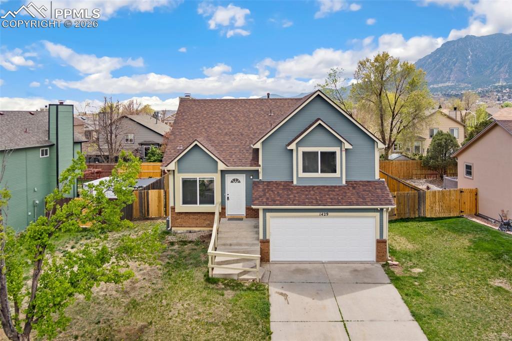 Image 2 of 35: View of front of property featuring roof with shingles, brick siding, concr