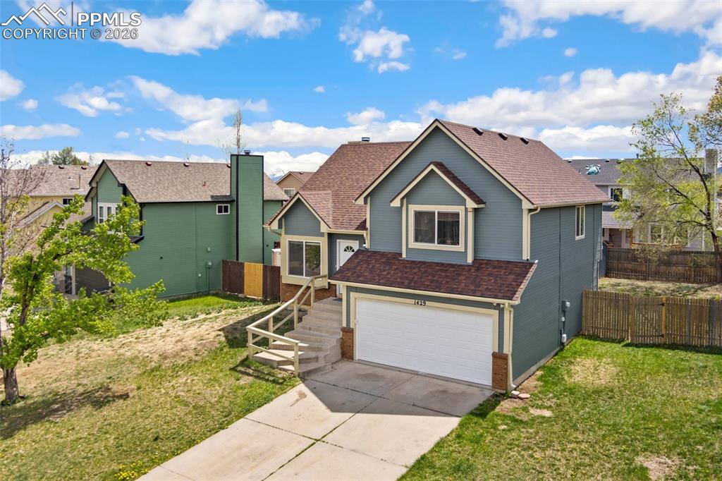 Image 3 of 35: View of front facade featuring driveway, a garage, a shingled roof, and a r