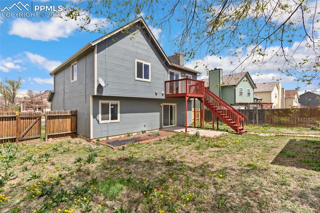 Image 31 of 35: Rear view of property with a fenced backyard, a deck, a gate, a residential