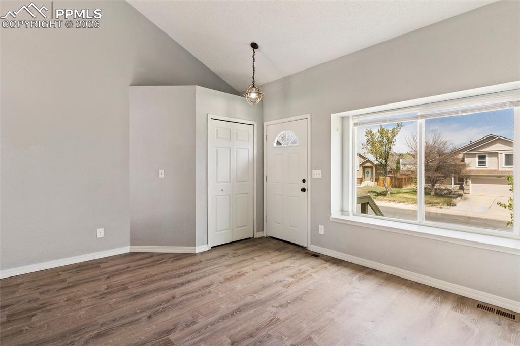 Image 5 of 35: Entryway featuring wood finished floors and vaulted ceiling