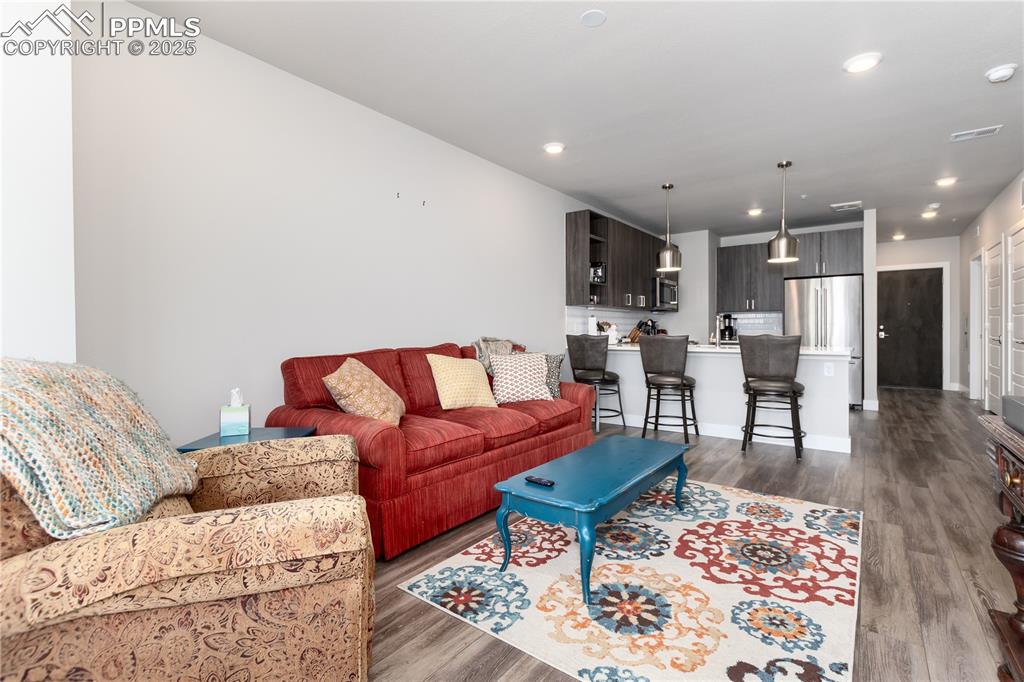 Image 12 of 21: Living area with dark wood-style flooring and recessed lighting