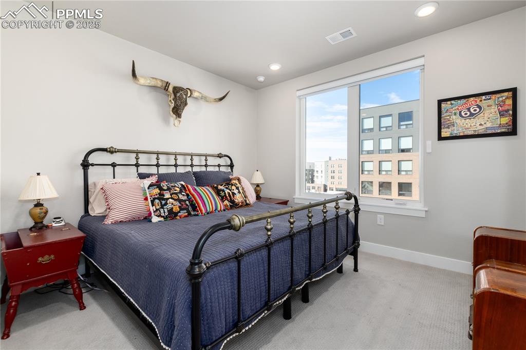 Image 15 of 21: Bedroom with light colored carpet and recessed lighting