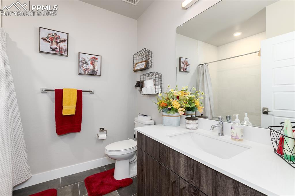 Image 20 of 21: Full bath featuring vanity, curtained shower, and dark tile patterned floor
