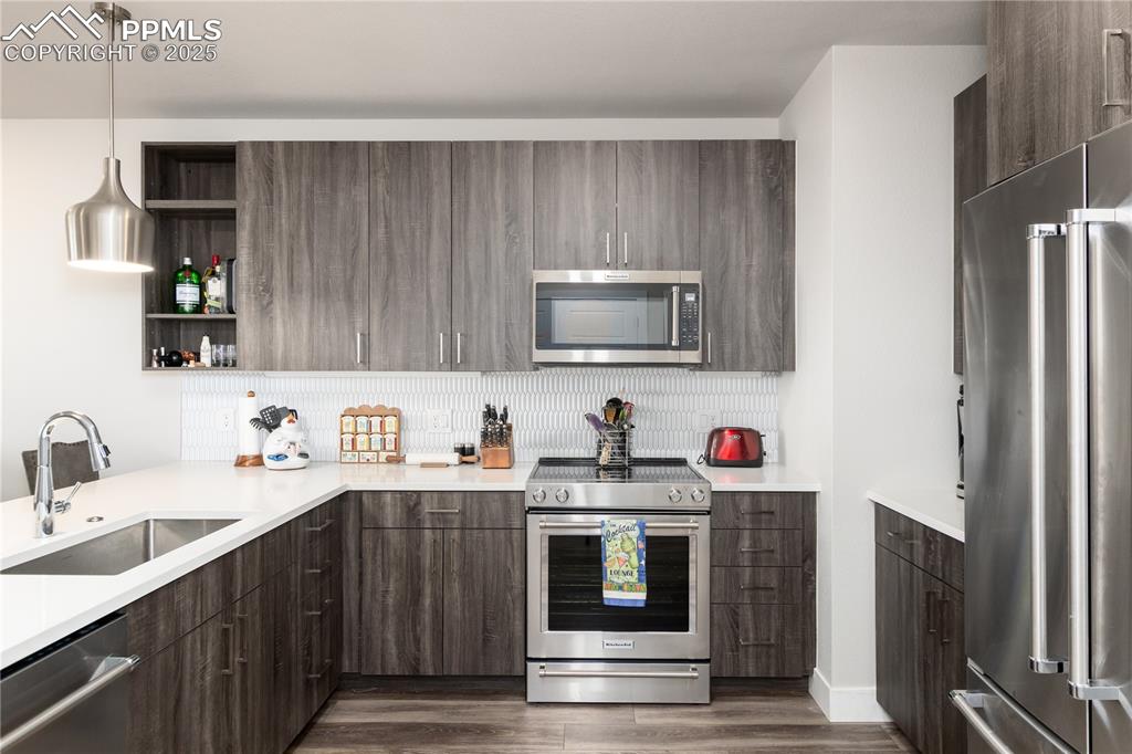 Image 4 of 21: Kitchen featuring high quality appliances, decorative light fixtures, open