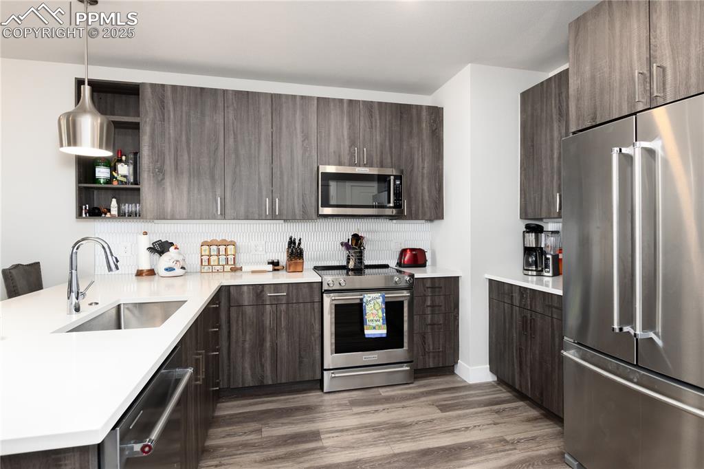 Image 5 of 21: Kitchen with stainless steel appliances, a peninsula, light wood-type floor