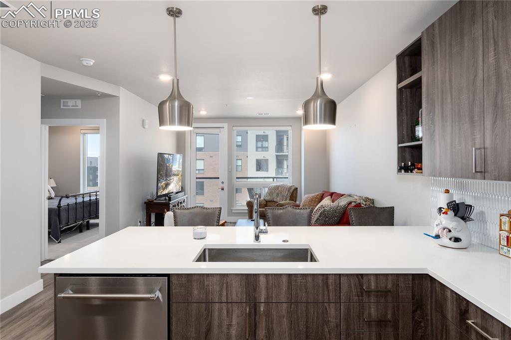 Image 8 of 21: Kitchen featuring dark brown cabinetry, open floor plan, modern cabinets, a