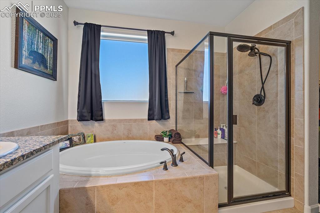 Image 17 of 35: Full bath with a shower stall, a garden tub, and vanity