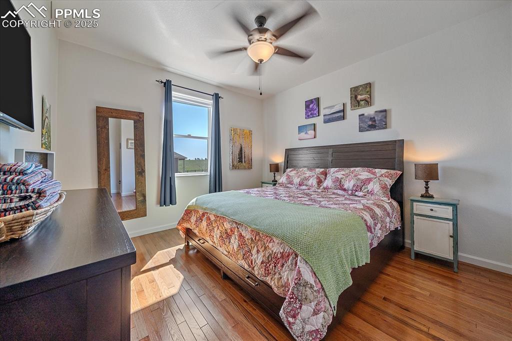 Image 18 of 35: Bedroom with baseboards, wood-type flooring, and a ceiling fan