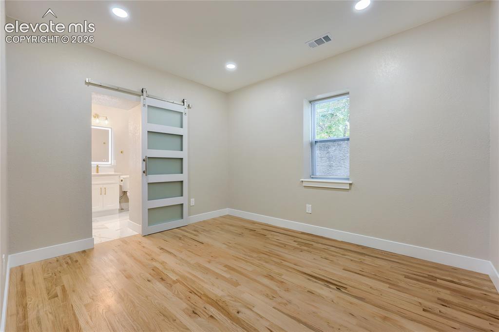 Image 17 of 49: The generously-sized primary suite is your warm-lit, private retreat. It is