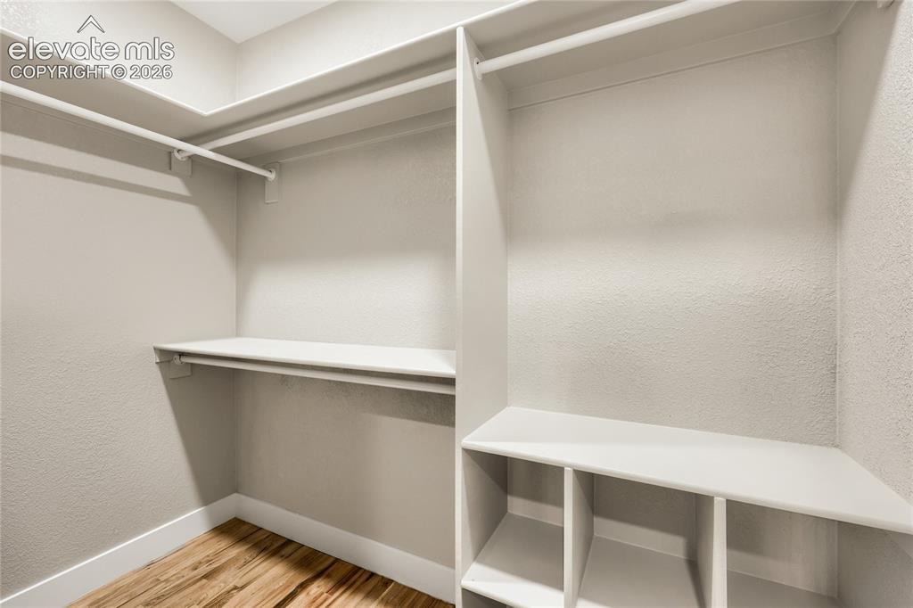 Image 21 of 49: Walk-in closet in the primary bedroom, with built-in shelving for the close