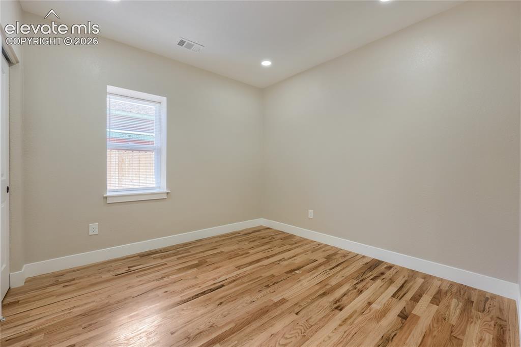 Image 28 of 49: A well-sized second bedroom is comfortable, featuring soft natural light, h