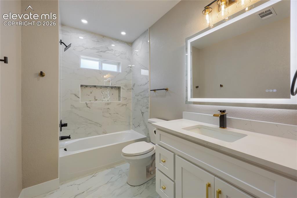 Image 36 of 49: The beautiful and spacious main hall bathroom, features a gorgeous marble t