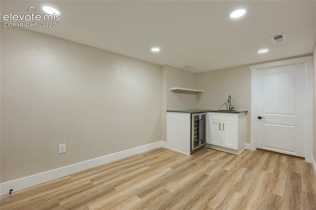 Image 38 of 49: The basement, featuring a roomy den/living area, kitchenette, utility room 