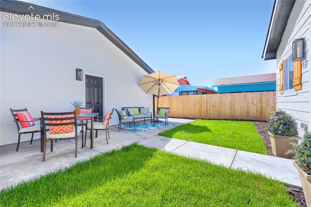 Image 42 of 49: The backyard features a wonderful back patio, with plenty of room for a din