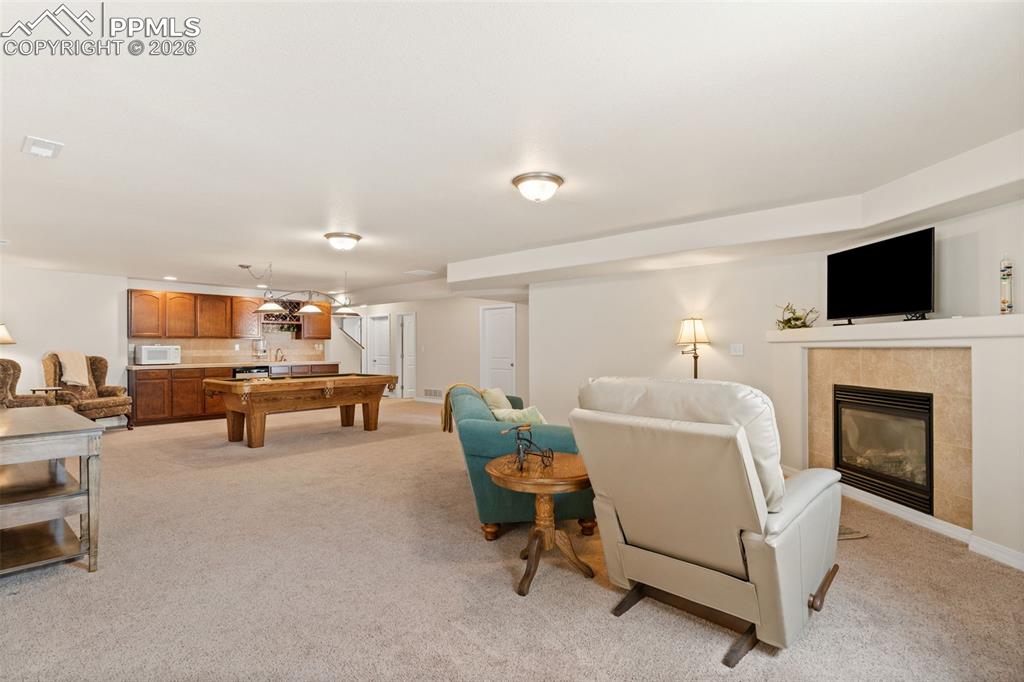 Image 24 of 31: Spacious family room with wet bar, fireplace & included pool table