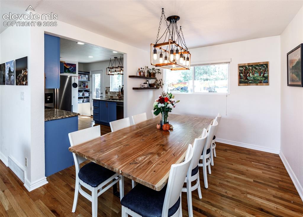Image 10 of 47: Wood-finish flooring throughout, with a framed opening leading to a kitchen