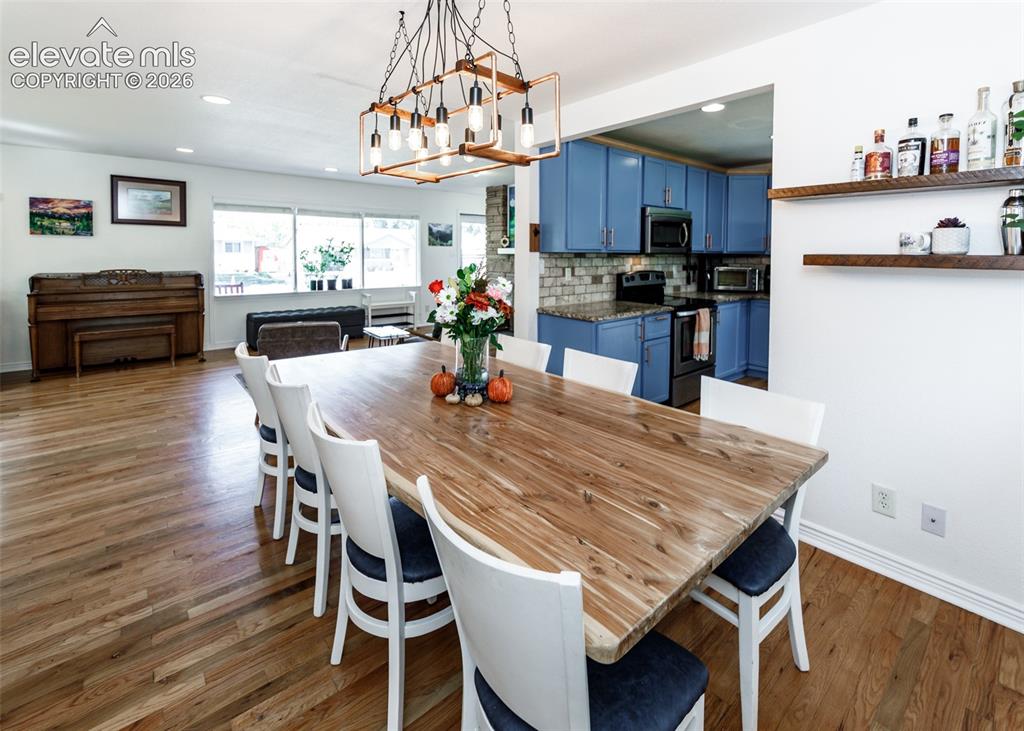 Image 11 of 47: Hardwood flooring throughout, recessed lighting, and a linear chandelier