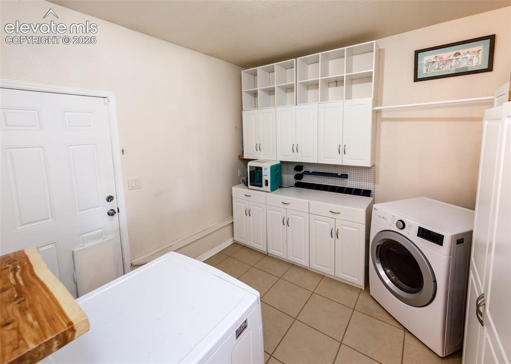 Image 16 of 47: White cabinetry with integrated shelving provides extensive storage