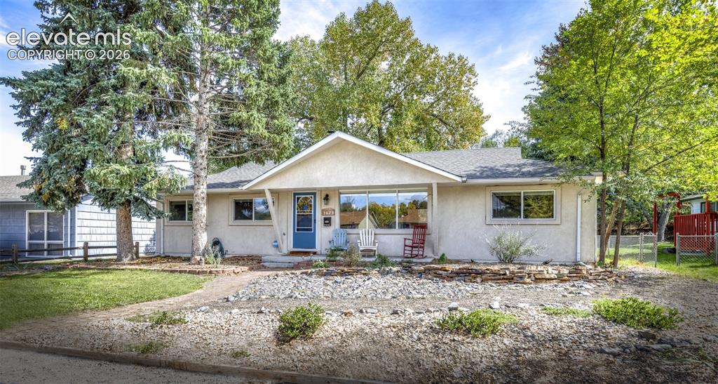 Image 2 of 47: Ranch-style exterior with a contrasting blue entry door, multiple windows,