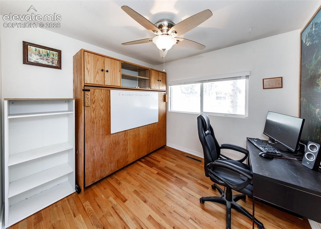 Image 22 of 47: Wood-finish flooring, built-in cabinetry with integrated whiteboard, and a