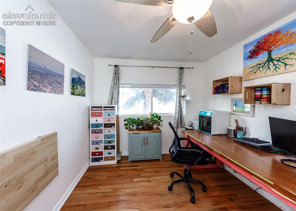 Image 24 of 47: Wood-finish flooring, ceiling fan with light fixture, built-in wall desk, w