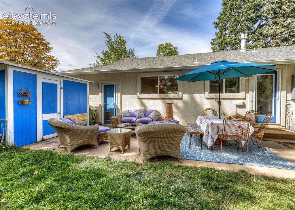 Image 28 of 47: Expansive concrete patio with direct outdoor access and a detached storage 