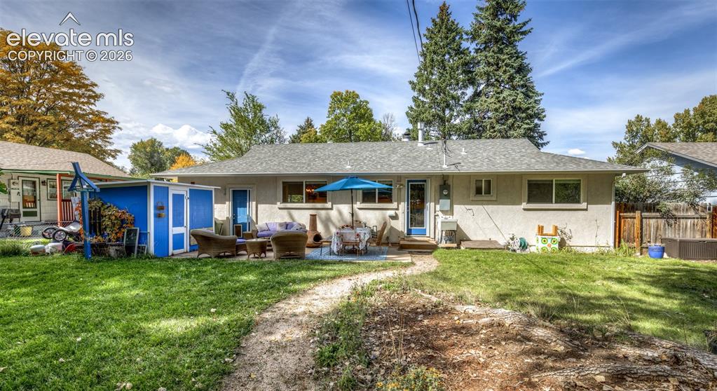 Image 32 of 47: Expansive backyard featuring a concrete patio, a detached storage shed, and