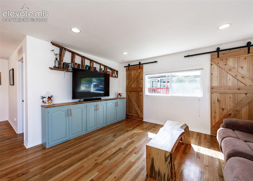 Image 7 of 47: Wood flooring, recessed lighting, built-in cabinetry with a wood countertop