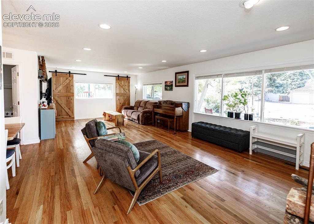 Image 9 of 47: Hardwood flooring throughout, recessed lighting, and large windows