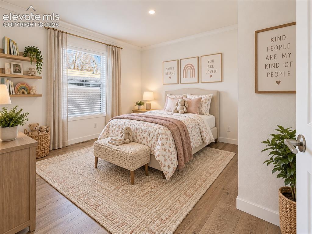 Image 30 of 47: Bedroom – Bright secondary bedroom features a large window, wide-plank floo