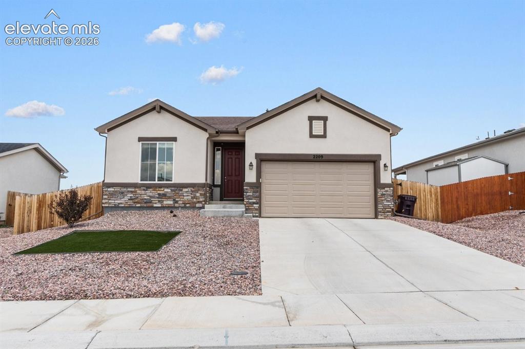 Caption: Modern single-story residence featuring a clean stucco exterior with stone accents, dual-pitched roo