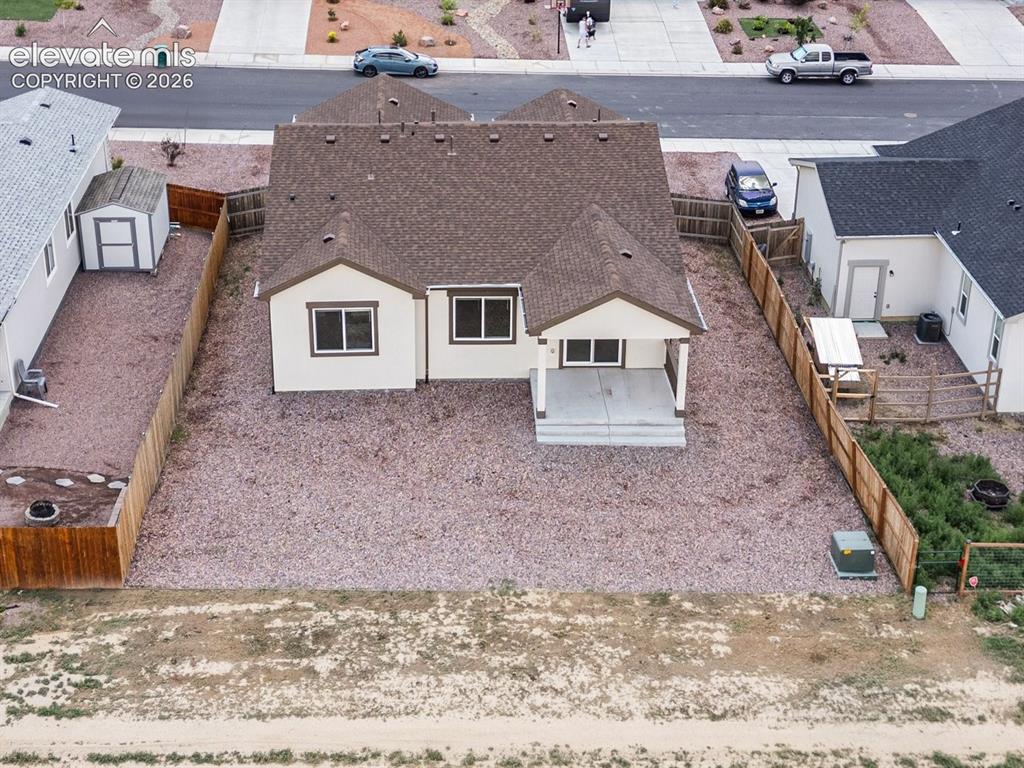 Image 24 of 25: Single-story residence featuring a brown shingle roof, light-colored exteri