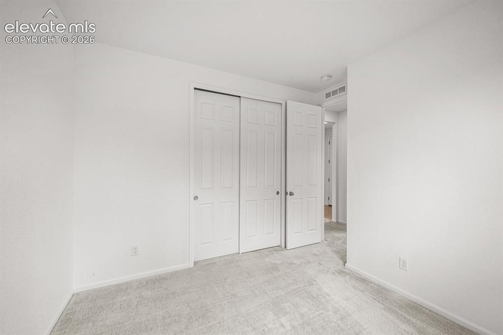 Image 8 of 25: Spacious bedroom featuring triple-panel closet doors with vertical detailin