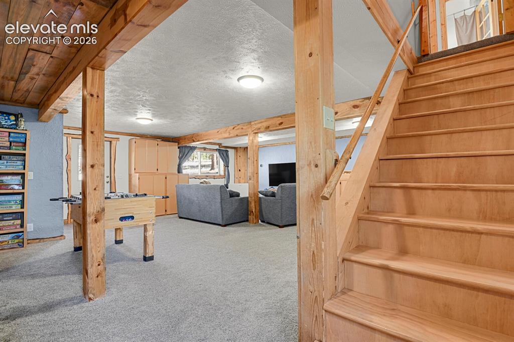 Image 25 of 46: Downstairs family room with beetle kill accents throughout