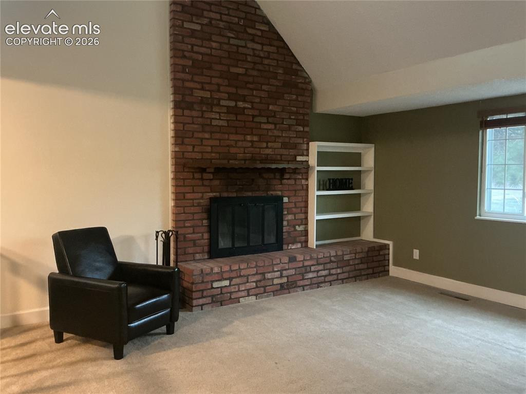 Image 4 of 24: Living room with wood-burning fireplace