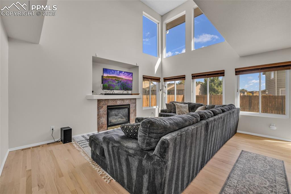 Image 11 of 40: Living room featuring a high ceiling, light wood-style flooring, and a tile