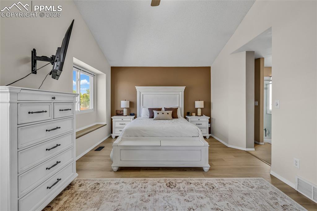 Image 14 of 40: Bedroom featuring light wood-style flooring, lofted ceiling, and ceiling fa