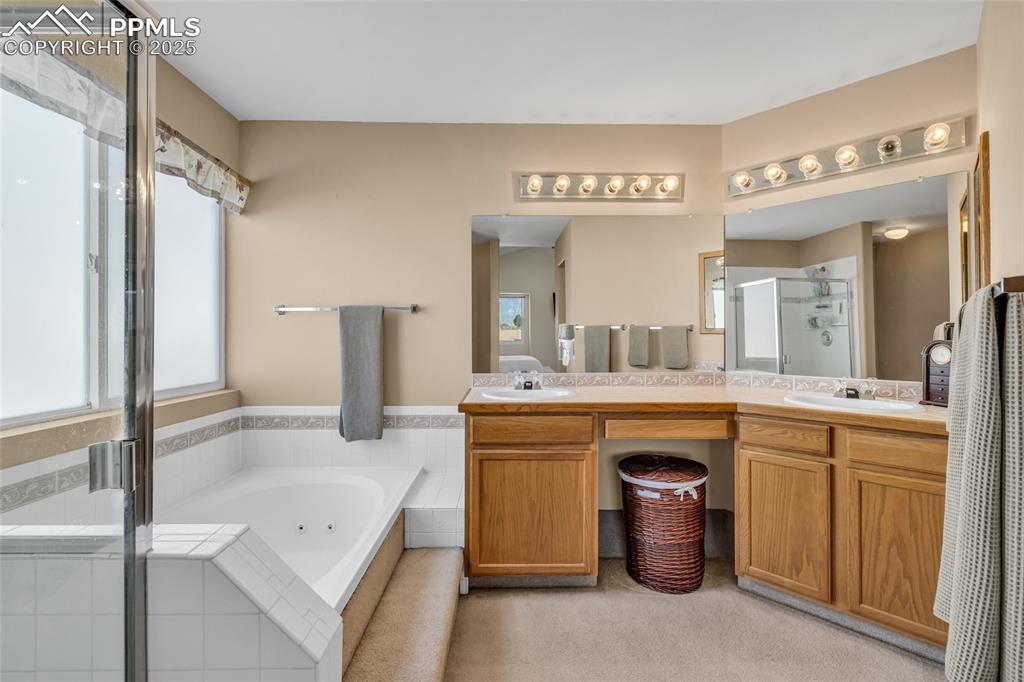 Image 16 of 40: Full bathroom with a shower stall, double vanity, and a whirlpool tub